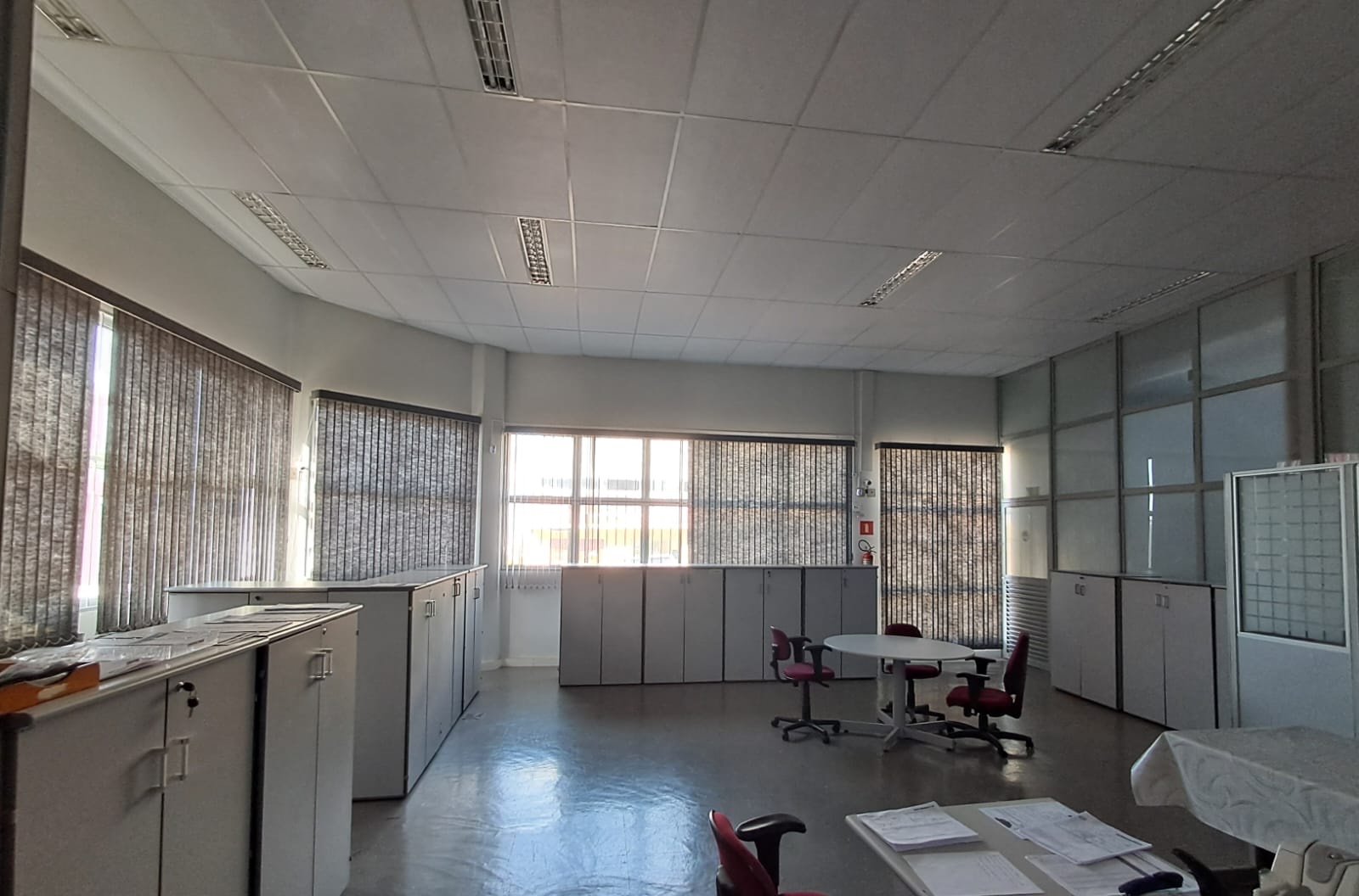 Sala privativa de retaguarda com armários e mesa de reunião